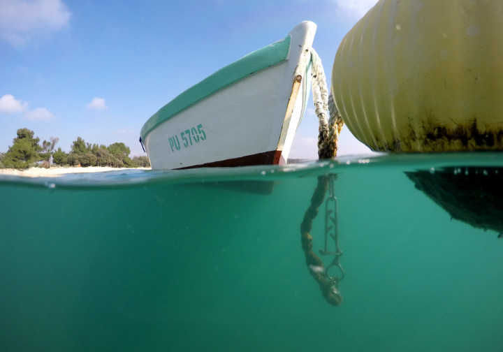 Half half photo of a boat and a buoy